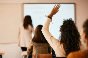 Student raising hand in classroom
