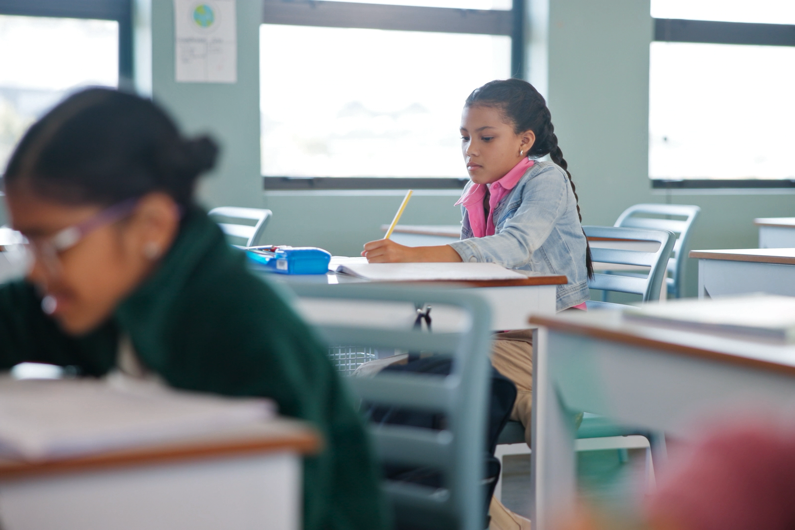 A student studies in a classroom with multiple empty desks