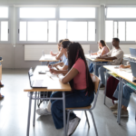 Female Teacher explaining lesson to high school students